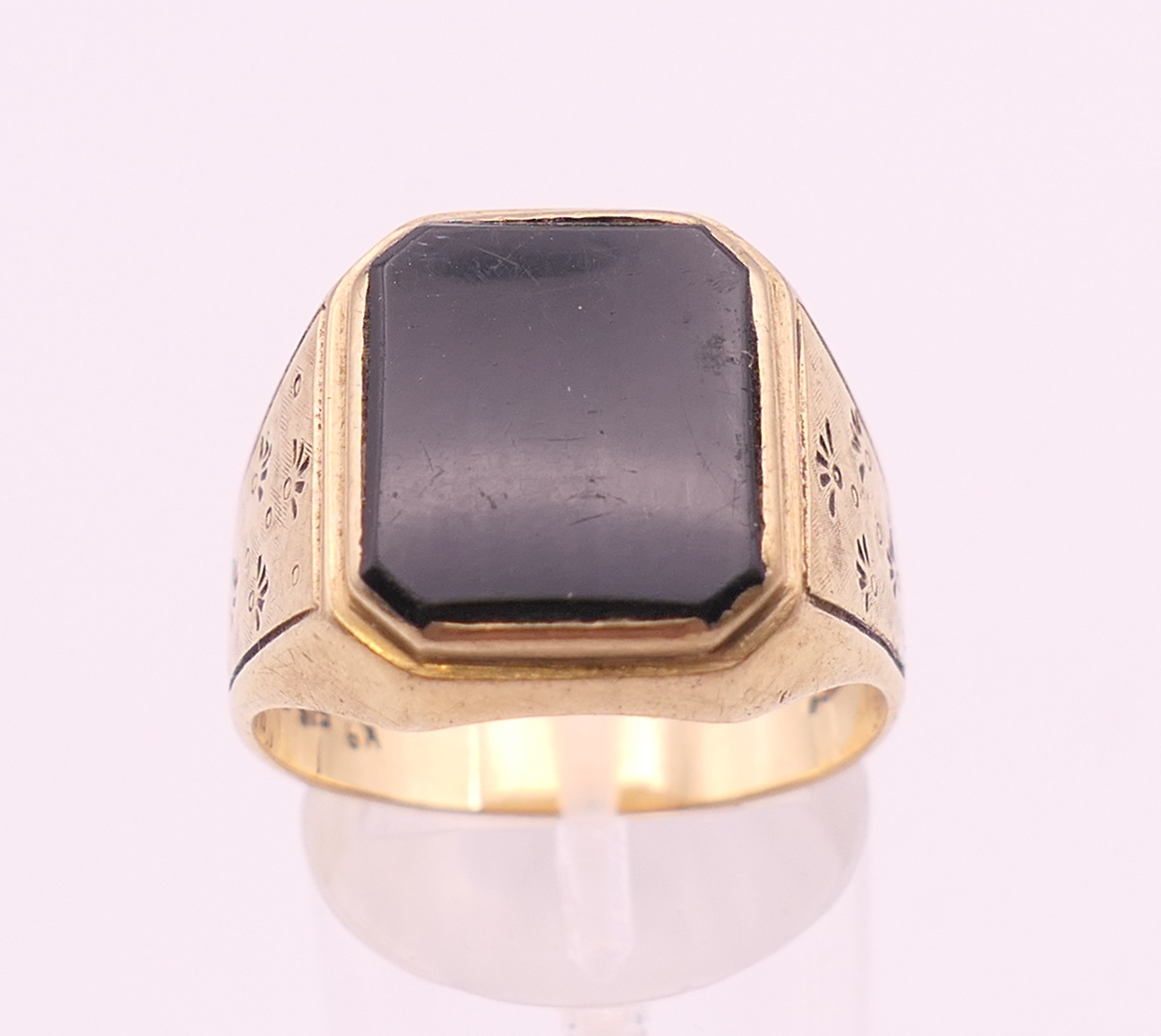 A 9 ct gold gentleman's onyx set ring. Ring size V. 7.4 grammes total weight.