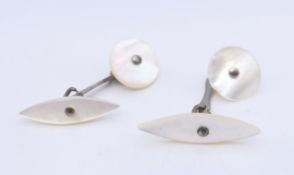 A pair of mother-of-pearl cufflinks. Oval shape 2.75 cm long, circle 1.5 cm diameter.