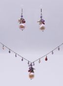 A pearl set necklace on a silver chain and a pair of matching earrings.