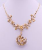 An unmarked gold seed pearl set necklace of scrolling floral form and detachable pendant formed as