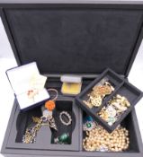 A jewellery box containing a quantity of costume jewellery.