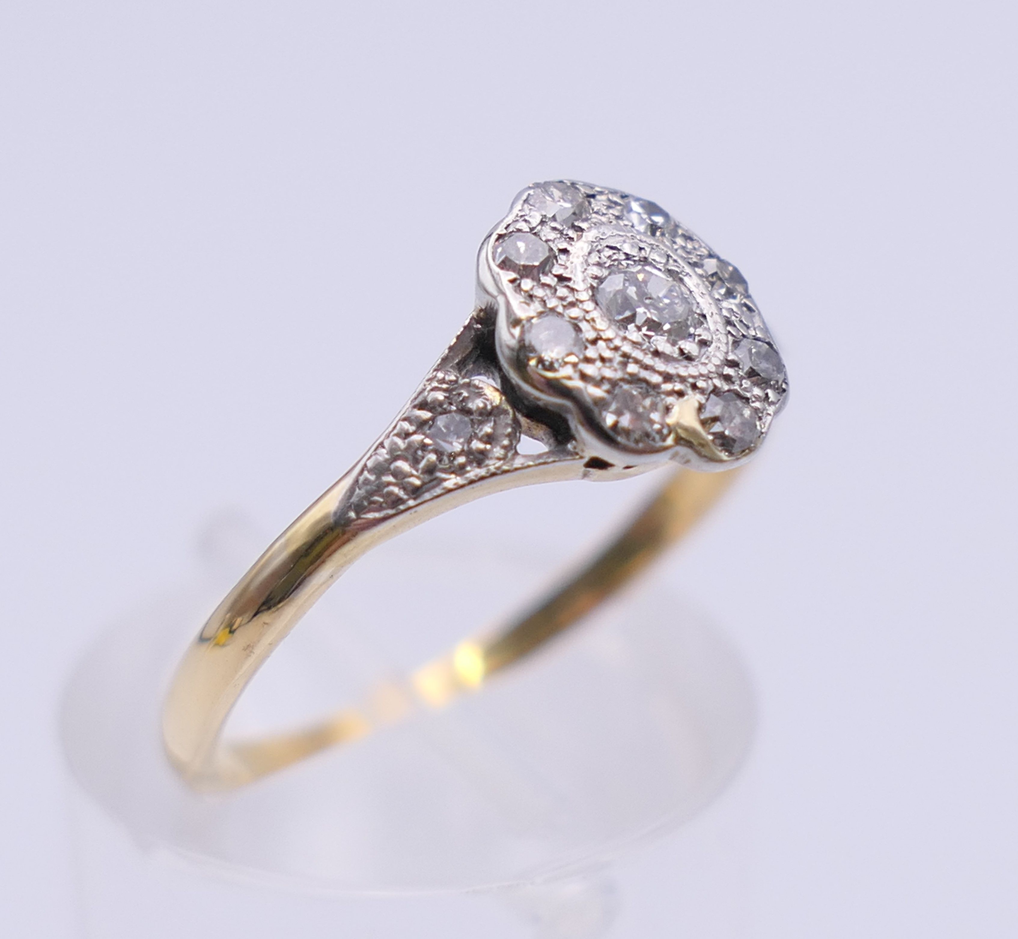 An Edwardian 18 ct gold oval diamond cluster ring. Ring size M. 2.3 grammes total weight. - Image 4 of 8