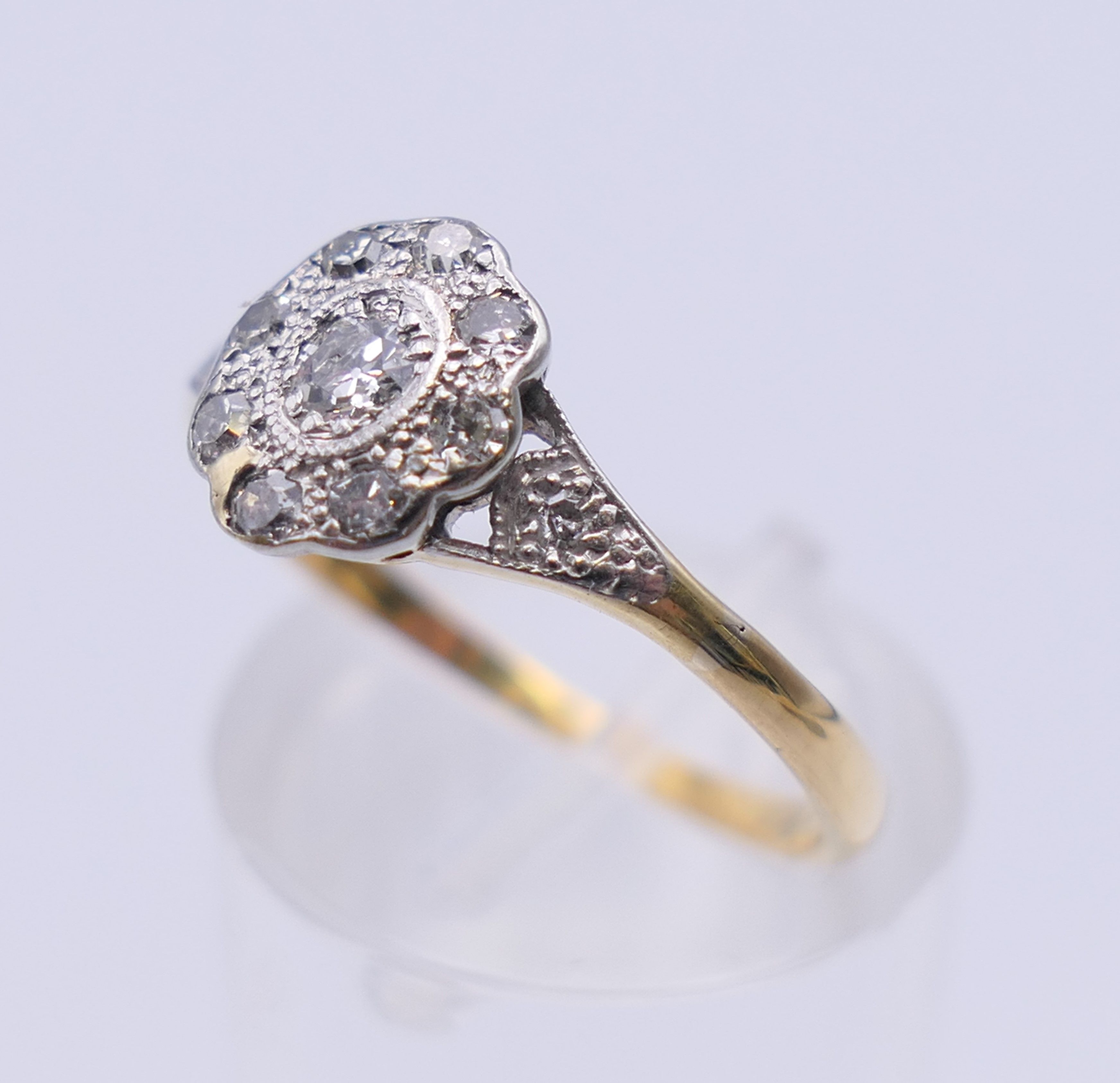 An Edwardian 18 ct gold oval diamond cluster ring. Ring size M. 2.3 grammes total weight. - Image 5 of 8