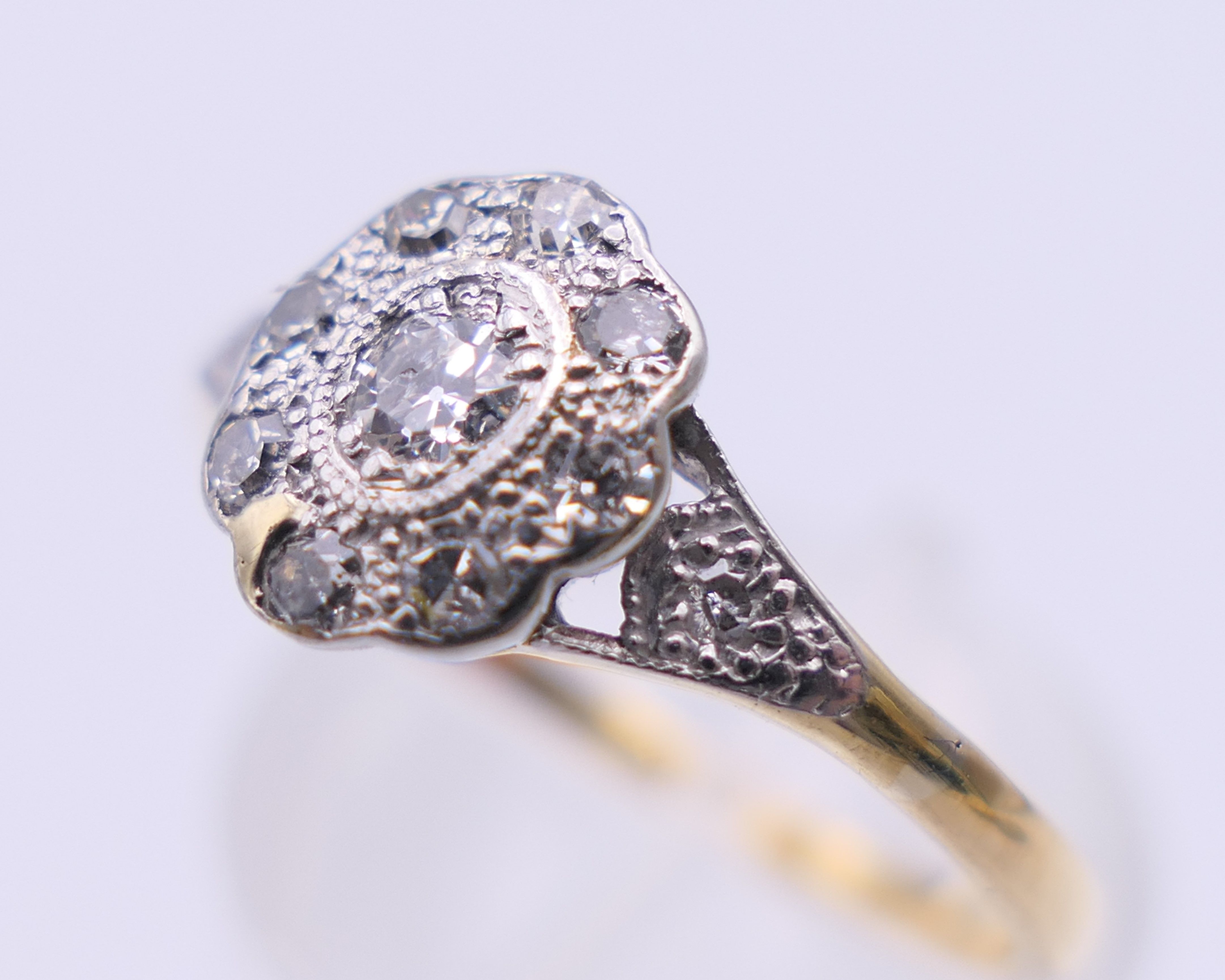 An Edwardian 18 ct gold oval diamond cluster ring. Ring size M. 2.3 grammes total weight. - Image 6 of 8