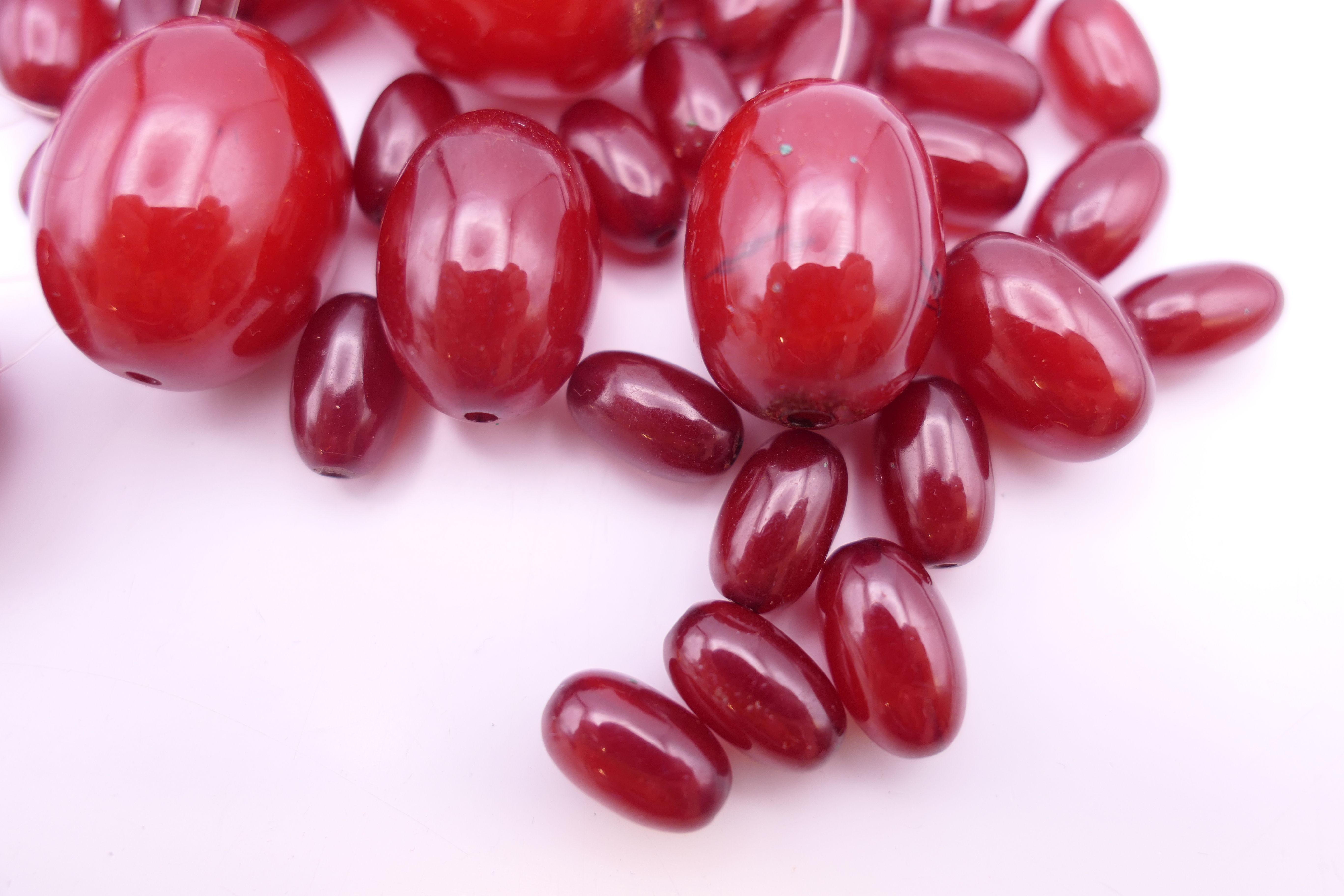 An amber bead necklace (approximately 38 cm long) and a quantity of cherry amber beads. - Image 3 of 9