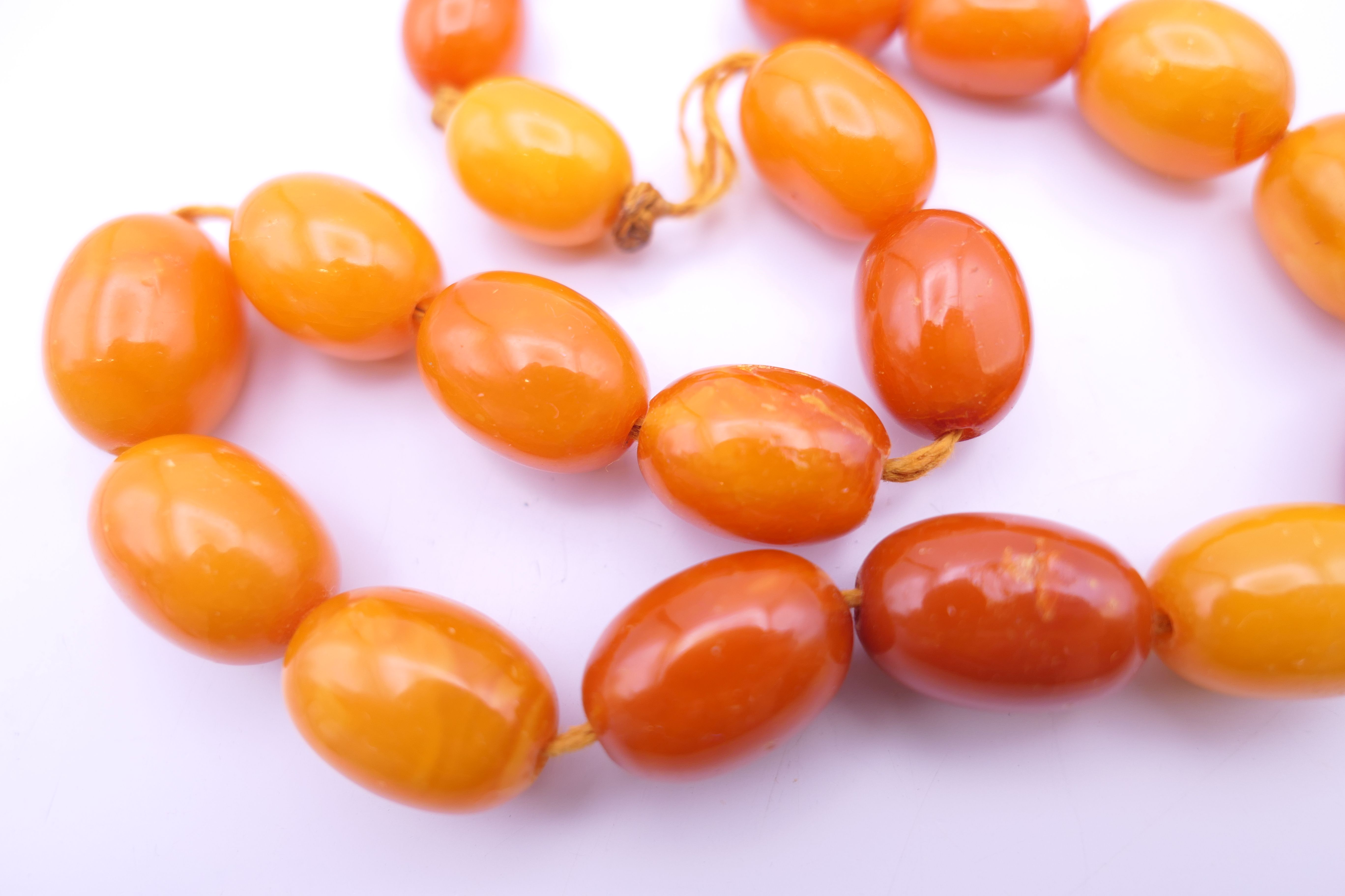 An amber bead necklace (approximately 38 cm long) and a quantity of cherry amber beads. - Image 5 of 9