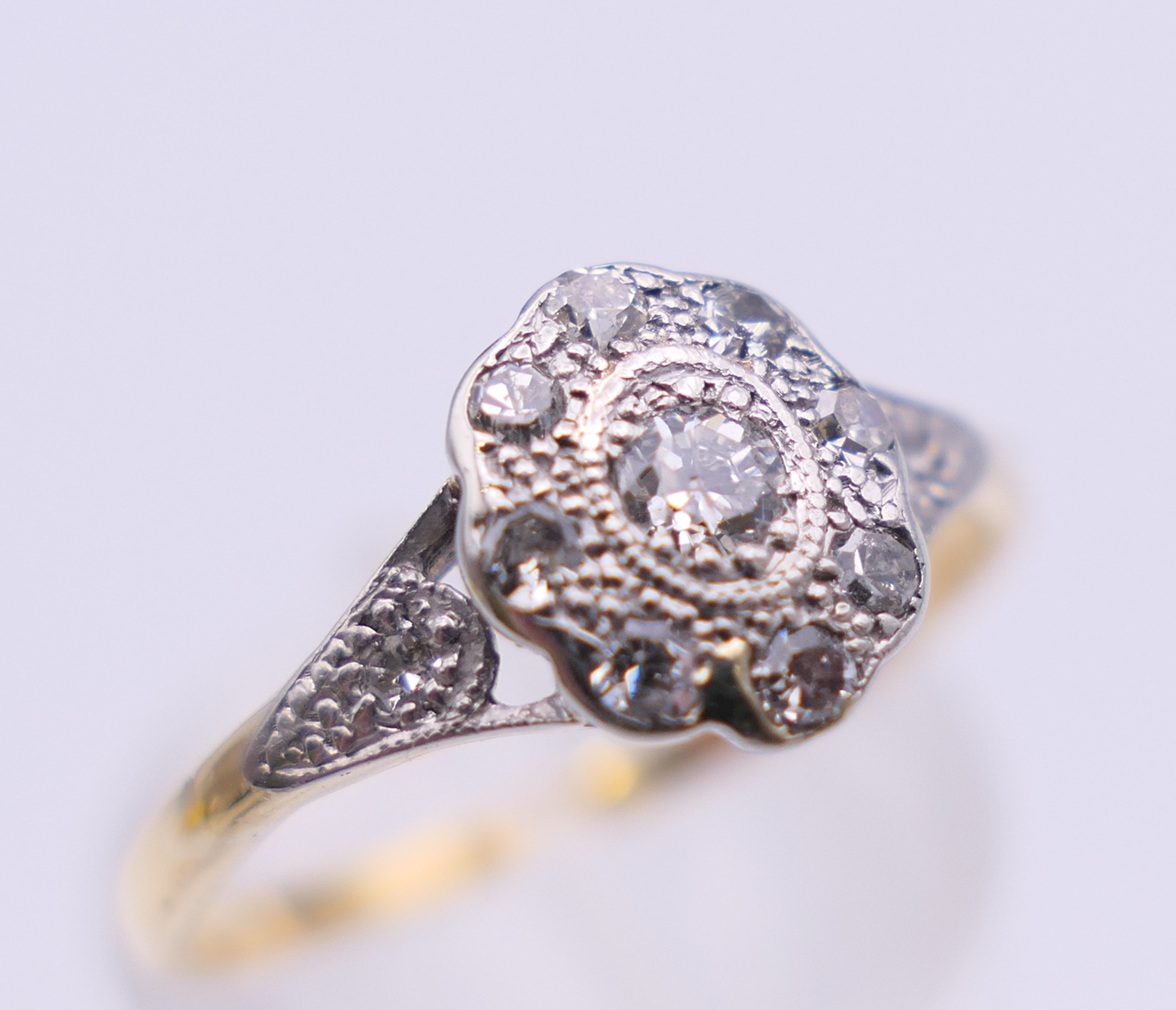 An Edwardian 18 ct gold oval diamond cluster ring. Ring size M. 2.3 grammes total weight. - Image 7 of 8
