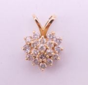 A gold diamond heart pendant. 1.25 cm high. 1.3 grammes total weight.