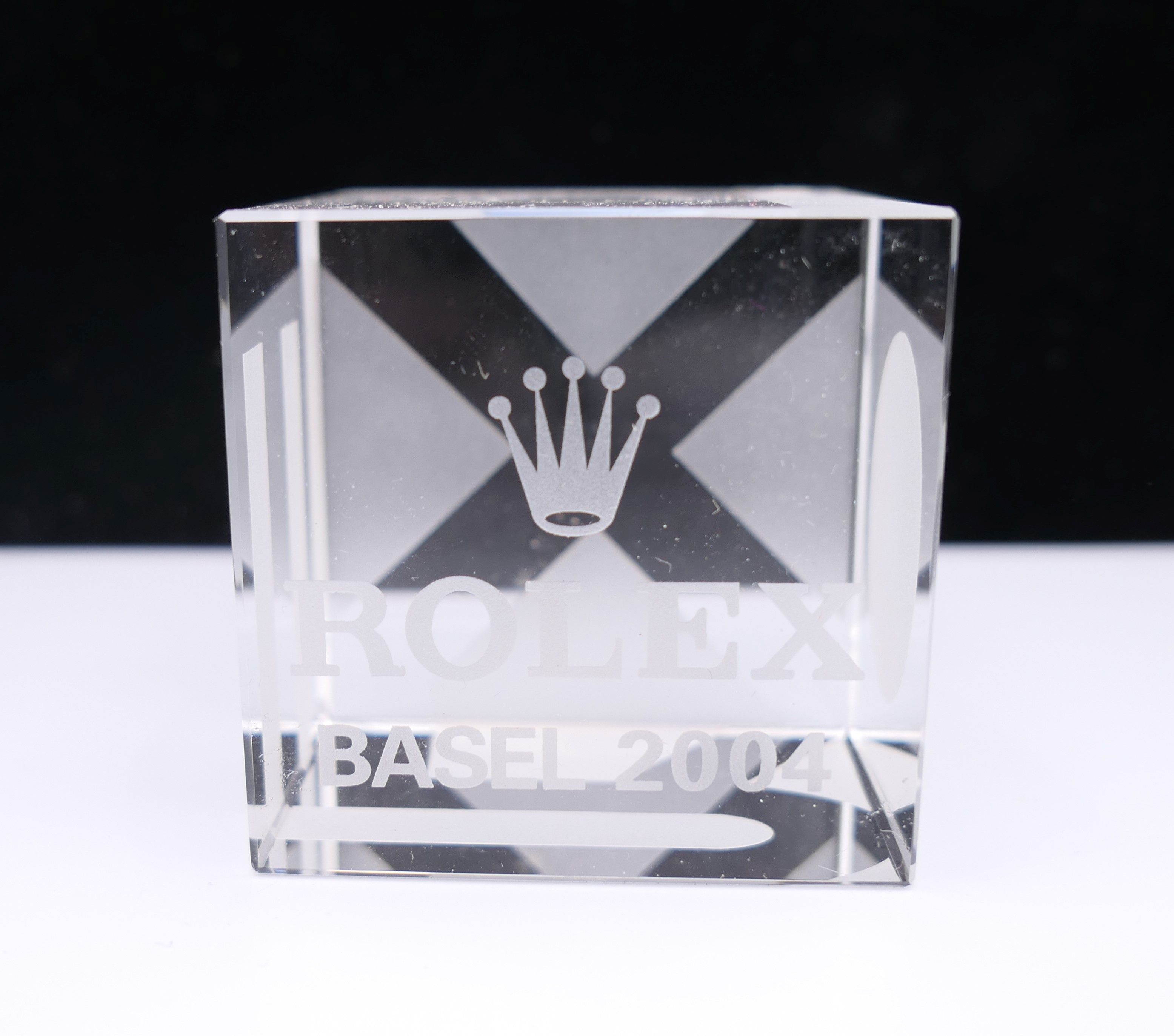 A Rolex glass paperweight. 5 cm wide.