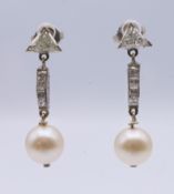 A pair of Art Deco diamond and pearl earrings. 3 cm high.