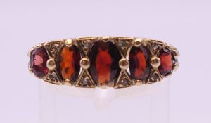 A 9 ct gold garnet and diamond ring. Ring size P. 5.2 grammes total weight.