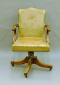 A leather upholstered revolving desk chair. 62 cm wide.