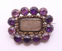 A 19th century unmarked gold amethyst and hair plait mourning brooch. 2.5 cm wide.
