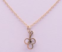 A small 9 ct gold pendant on a 9 ct gold chain. The pendant 1.5 cm high. 1.8 grammes total weight.