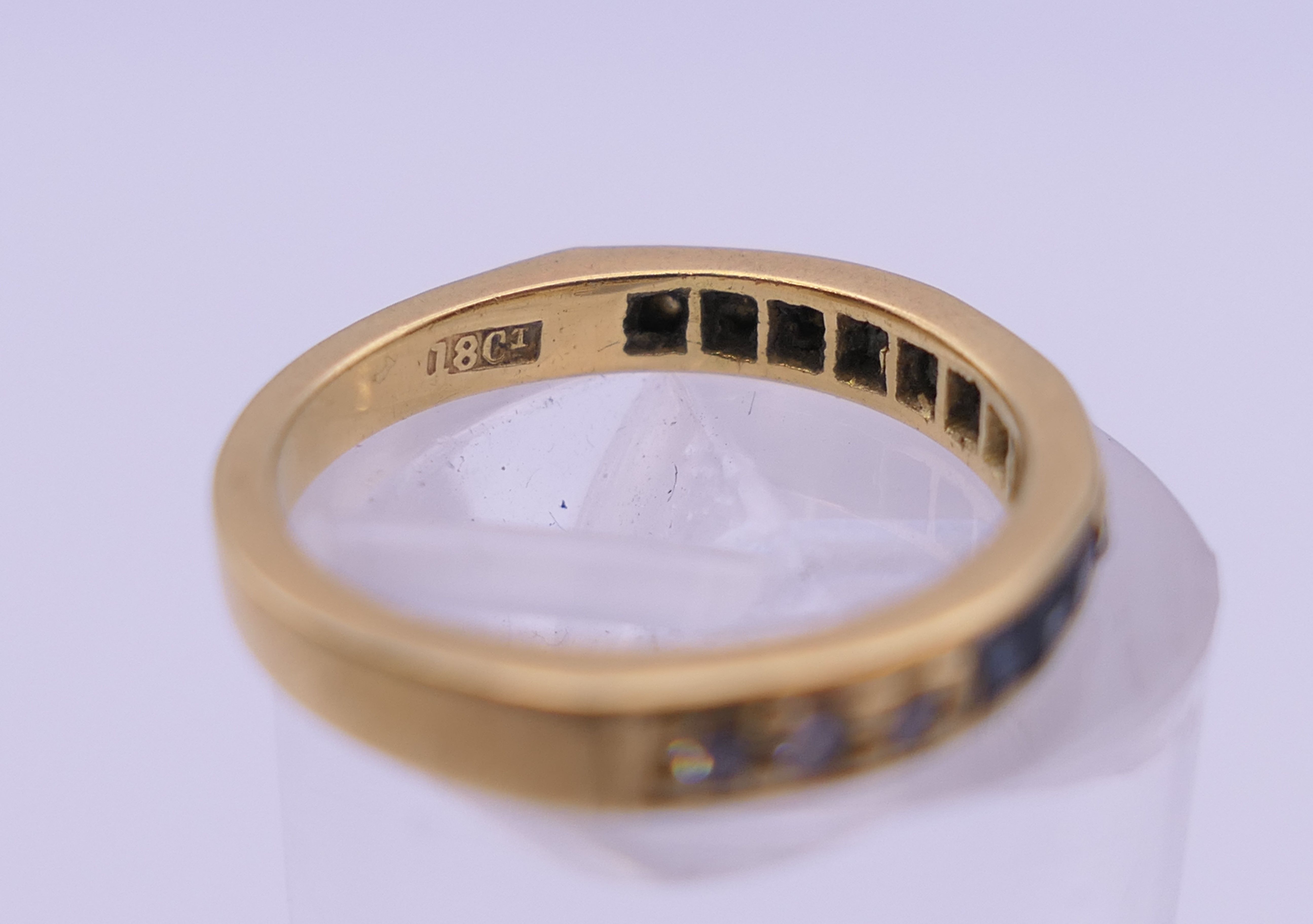 An 18 ct gold diamond and sapphire half eternity ring. Ring size H/I. 2.7 grammes total weight. - Image 3 of 3
