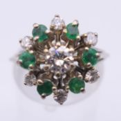 An 18 ct gold diamond and emerald ring. Ring size M. 5.8 grammes total weight.
