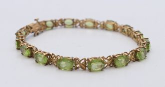 A 14 ct gold peridot bracelet. 18 cm long. 10.6 grammes total weight.
