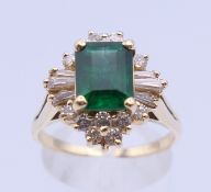 An unmarked gold emerald cluster ring. Ring size S/T. 6.2 grammes total weight.