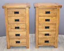 A pair of contemporary solid oak chests of five drawers with black drop handles, W57 x D42 x H101cm