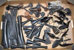 A large collection of violin / viola / cello accessories including tailpieces, tuning pegs and