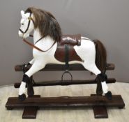 Carved wooded Rocking Horse with leather and metal fittings on trestle base, length 117cm