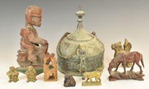 A group of carved figures including an African soldier or similar riding a motorcycle etc tallest