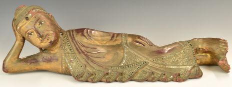 Large carved wooden figure of a young reclining Buddha, with jewelled decoration, height 21 x length