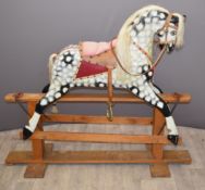 Carved wooden Rocking Horse with leather and metal fittings on trestle base length 142cm