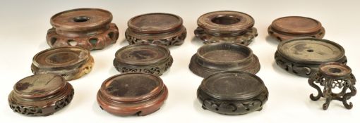 Twelve Chinese 19th / 20thC carved hardwood stands, maximum diameter 16cm