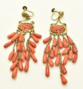 A pair of Chinese silver earrings set with carved coral depicting a bird, with coral drop