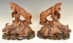Two pairs of Chinese wooden carvings, one in the form of figures riding water buffalo, the other