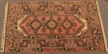 Afghan rug with three central guls on a pink and mauve ground, 210 x 116cm
