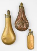 Three copper and brass powder flasks comprising one Sykes, one with embossed decoration and one Colt