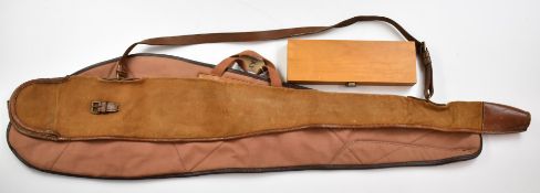 Two leather and canvas shotgun or rifle slips together with a shotgun cleaning kit.
