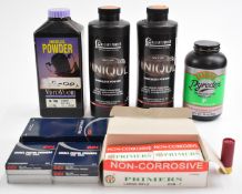 A collection of shotgun cartridge re-loading items including smokeless powder and primers.