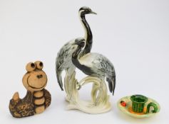 Karl Ens porcelain figure of two herons, Japanese chamber stick and John Hughes pottery snail,