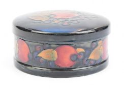 Moorcroft circular covered container decorated in the Pomegranate pattern with blue signature to
