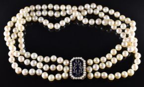A triple strand of cultured pearls with a rose gold clasp set with blue guilloché enamel mounted