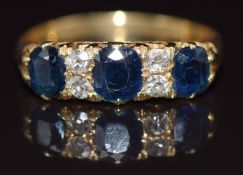 An 18ct gold ring set with three sapphires and four diamonds, size Q