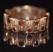 A 9ct gold eternity ring with textured finish set with garnets, 3.6g, size K