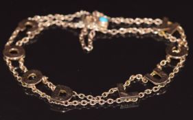 A c1900 9ct gold bracelet reading 'Good Luck' with a turquoise cabochon to clasp, 8.2g