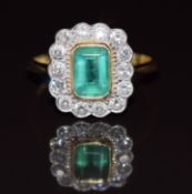An 18ct gold ring set with an emerald cut emerald of approximately 1ct surrounded by diamonds, 3.4g,