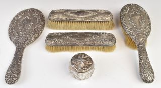 Edward VII hallmarked silver dressing table set comprising hand mirror and three various brushes,