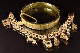A rolled gold bangle with ridged decoration, marked KJ Amerio and a gold plated charm bracelet set