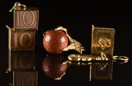Five 9ct gold charms including two 10 shilling notes, cello, claw set with sunstone and a bible,
