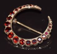 A 9ct gold crescent brooch set with graduated garnets, 4.4g