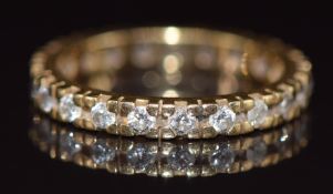 An 18ct gold eternity ring set with twenty round cut diamonds, 3.3g, size L/M