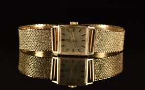 Omega 9ct gold ladies wristwatch with black hands, two-tone baton hour markers, silver dial and