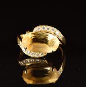 An 18ct gold set with an oval cut citrine and diamonds in a twist setting, 3.8g, size K