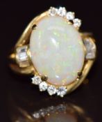 A 14k gold ring set with a white opal of approximately 7ct surrounded by baguette and round cut
